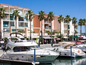 a group of boats docked in a marina with a building at Pavillon climatisé avec terrasse, 10 min. de la plage, parking privatif inclus, tout confort - FR-1-732-45 in Argelès-sur-Mer