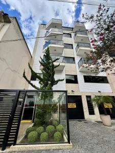 a christmas tree in front of a building at Conforto e Praticidade no Centro de Friburgo! in Nova Friburgo