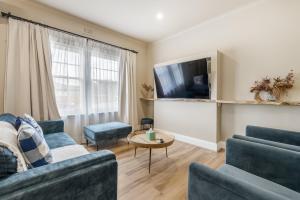 a living room with two blue couches and a tv at Stylish Family Getaway with Modern Comforts in Moonah