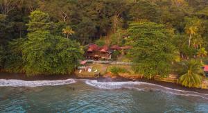 une vue aérienne sur une maison au bord de l'eau dans l'établissement Hotel Bahía Aguacate, à Capurganá