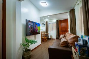 a living room with a couch and a television at Upper Bliss Homestay in El Nido