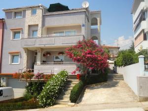 una casa con flores rosas en las escaleras en Pejić Apartments, en Pula