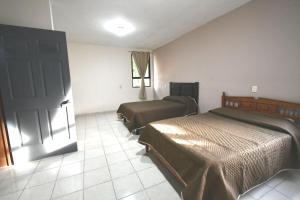 a hotel room with two beds and a door at Casa La Primavera RTH in Comitán de Domínguez