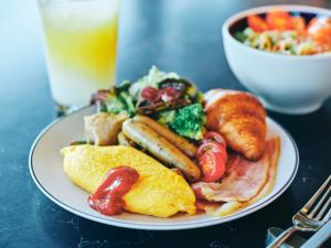 a plate of breakfast food with eggs sausage and toast at Canopy By Hilton Osaka Umeda in Osaka