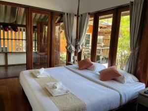 ein Schlafzimmer mit zwei Betten und einem großen Fenster in der Unterkunft Ban Tha Ton Do Koh Yao noi in Ko Yao Noi