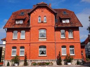 ein großes rotes Backsteingebäude mit rotem Dach in der Unterkunft Landhaus Jürgens in Sehnde