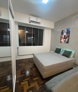 Un dormitorio con una cama y un cuadro en la pared. en Excelente perto do Aeroporto e Metro e 3 km das Praias, en Río de Janeiro