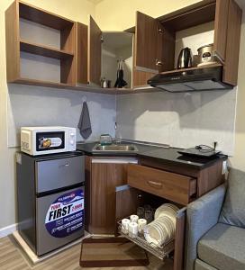 宿务Cushy Condo at Avida, IT Park Cebu的一个小厨房，里面有水槽和炉灶。