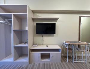 宿务Cushy Condo at Avida, IT Park Cebu的客房设有书桌、电视和桌子。