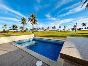 a swimming pool on a wooden deck with palm trees at casa con alberca en campo de golf by G P S rentas in Barrón
