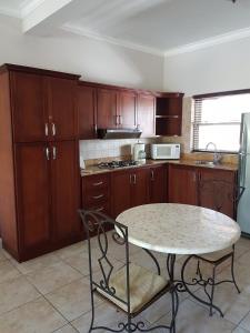 una cocina con armarios de madera y una mesa con sillas. en Garden Studio At Ocean Dream Resort, en Cabarete