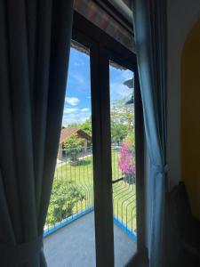 a glass door with a view of a yard at La Y Riverview in Hue