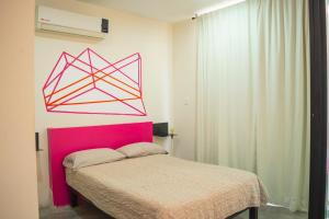 a bedroom with a bed with a pink head board at Loft a 3 cuadras de la playa by G P S rentas in Mazatlán +10 photos