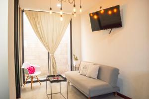 a living room with a couch and a tv at Loft a 3 cuadras de la playa by G P S rentas in Mazatlán