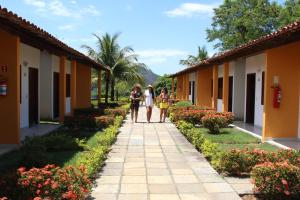 people walking down a sidewalk outside a building at Acquamarine Park Hotel in Guarapari