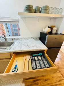 una cocina con un cajón con tijeras y cuchillos en Cozy Private Guesthouse with AC, en Chula Vista 6 fotos más
