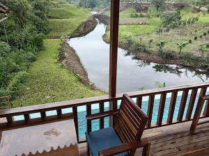 a chair on a balcony looking out at a river at Finca Procel in Palora