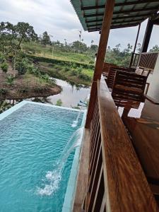 a swimming pool on the side of a house with a river at Finca Procel in Palora