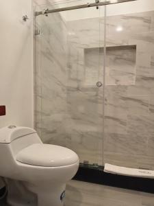 a bathroom with a toilet and a glass shower at Finca Procel in Palora +30 photos