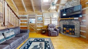 a living room with a couch and a fireplace at Sweet Scarlet Rose cabin in Sevierville