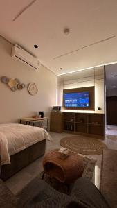a bedroom with a bed and a flat screen tv at مساكن المها - شقق وأستديوهات - بتأثيث متكامل ومريح in Al Khobar