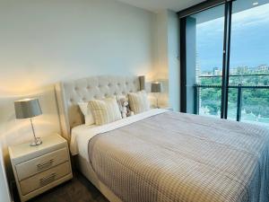 una camera da letto con un letto grande con una grande finestra di Brisbane CBD Luxury Apartment 8 Margaret St a Brisbane