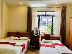 a bedroom with two beds and a window at Công Thành Hotel in Lao Cai