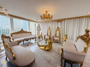 Una sala de estar con muebles dorados y una lámpara de araña. en El Palacio del Rey, en Lima