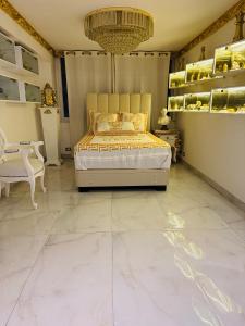 1 dormitorio con 1 cama extragrande y lámpara de araña en El Palacio del Rey, en Lima