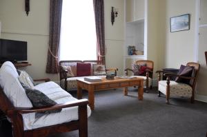 a living room with couches and a coffee table at Shunters Cottage in Waihi