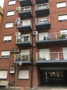 a brick building with balconies on the side of it at Torre Parque Apartamento in Morón