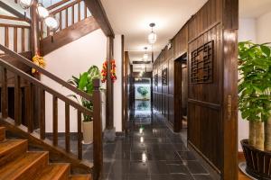 a hallway with wooden floors and stairs with potted plants at Huangshan Chuyuyuan Manju Homestay in Huangshan