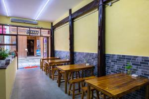 a row of wooden tables and chairs in a restaurant at Huangshan Chuyuyuan Manju Homestay in Huangshan