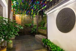 a hallway with plants and a wall with lights at Huangshan Chuyuyuan Manju Homestay in Huangshan