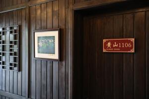 a sign on a wall next to a door at Huangshan Chuyuyuan Manju Homestay in Huangshan