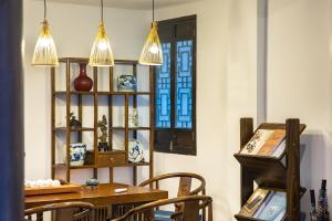 a room with a table and chairs and a window at Huangshan Chuyuyuan Manju Homestay in Huangshan