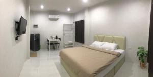 a small bedroom with a bed and a table at ก่อนเกาะโฮเทล แหลมงอบ Konkoh Laemngob in Laem Ngop