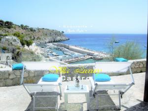 Blick auf einen Yachthafen mit 2 Stühlen und das Meer in der Unterkunft Villa Luxury in Castro di Lecce