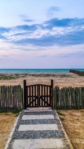 a wooden fence on the beach with the ocean at Refugio, Casa de la Playa in Manaure