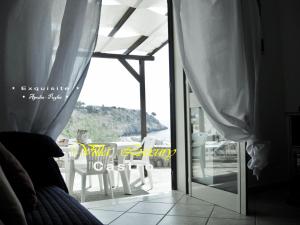 Schlafzimmer mit einer Tür, die auf eine Terrasse mit Stühlen führt in der Unterkunft Villa Luxury in Castro di Lecce