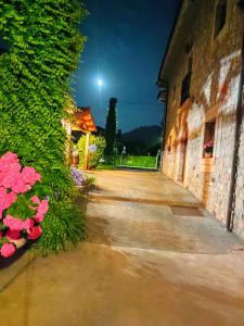 an alley with pink flowers next to a building at El Campo de Petra in Grado