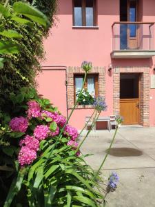a pink building with flowers in front of it at El Campo de Petra in Grado