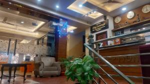 a lobby of a restaurant with a chair and a table at Hotel Rajshree in Tanakpur