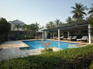 a swimming pool with tables and chairs next to a house at Happy Mind Resort in Sam Roi Yot