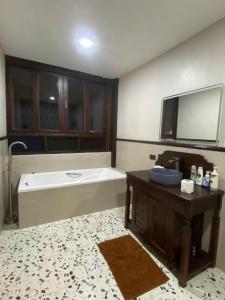 ein Badezimmer mit einer Badewanne, einem Tisch und einem Waschbecken in der Unterkunft Dalasone Pool Villa with Stunning Mountain View in Vang Vieng