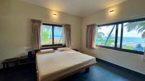 Un dormitorio con una cama con vista al mar. en Palm Gardens Beach View Villa, en Udupi