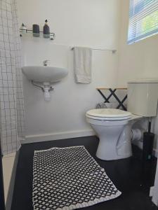 um banheiro com um vaso sanitário branco e uma pia em Majhiya on Ferndale apt em Gqeberha