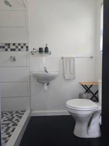 um banheiro branco com vaso sanitário e pia em Majhiya on Ferndale apt em Gqeberha