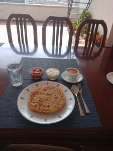 een pizza op een bord op een tafel bij Achates Corporate Services in Bangalore