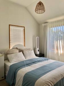 a bedroom with a large bed with a window at Homestay near CHC Airport in Christchurch